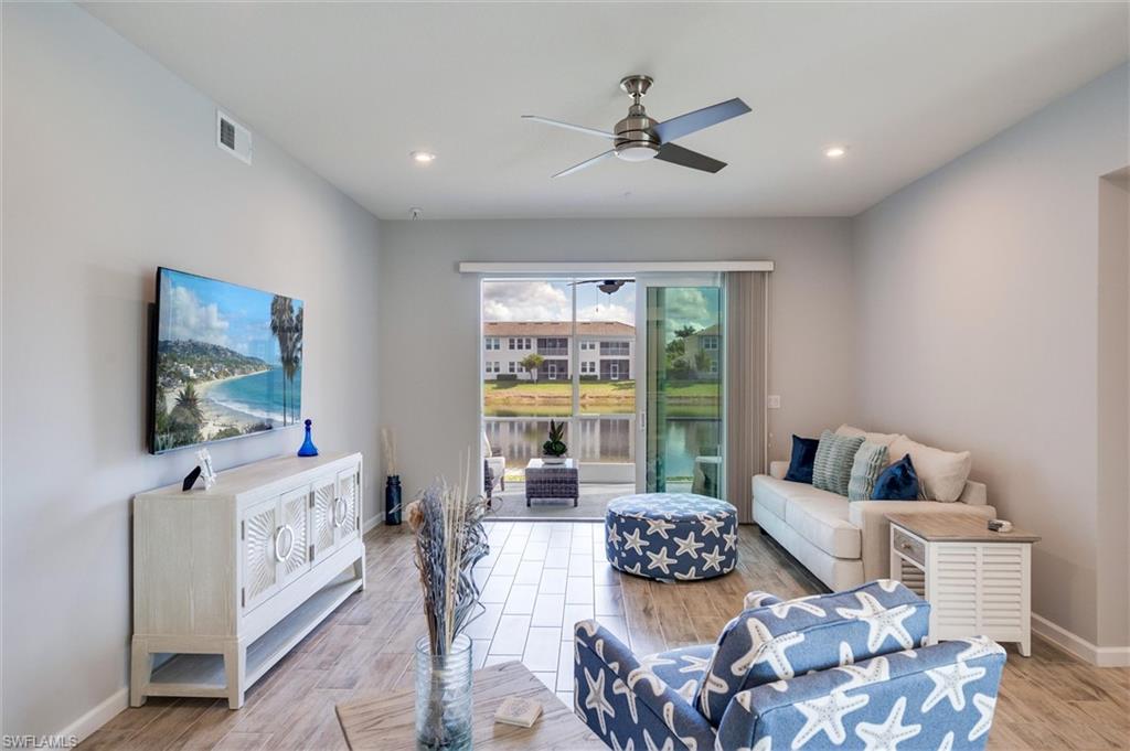 Living room with tile wood-look flooring, a ceiling fan, and recessed lighting