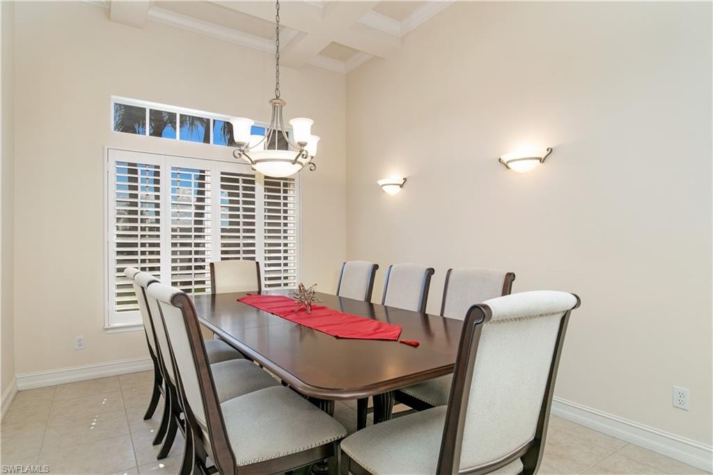 View of Formal Dining with Chandelier, Tray Ceiling, Wall Sconce Lighting and Plantation Shutters