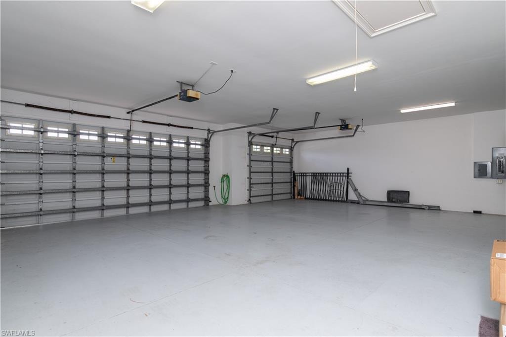 View of the HUGE Three Car Garage.  The Single Bay has its Garage Extension to Storage and Rear Garage Doorway to A/C equipment etc.  All are remote garage door openers.