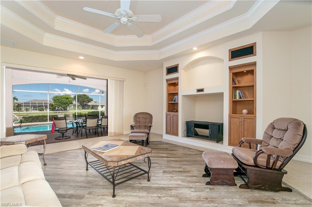 View of Coffered Greatroom Built In and Slider to Paver Lanai Under Truss and Pool Deck