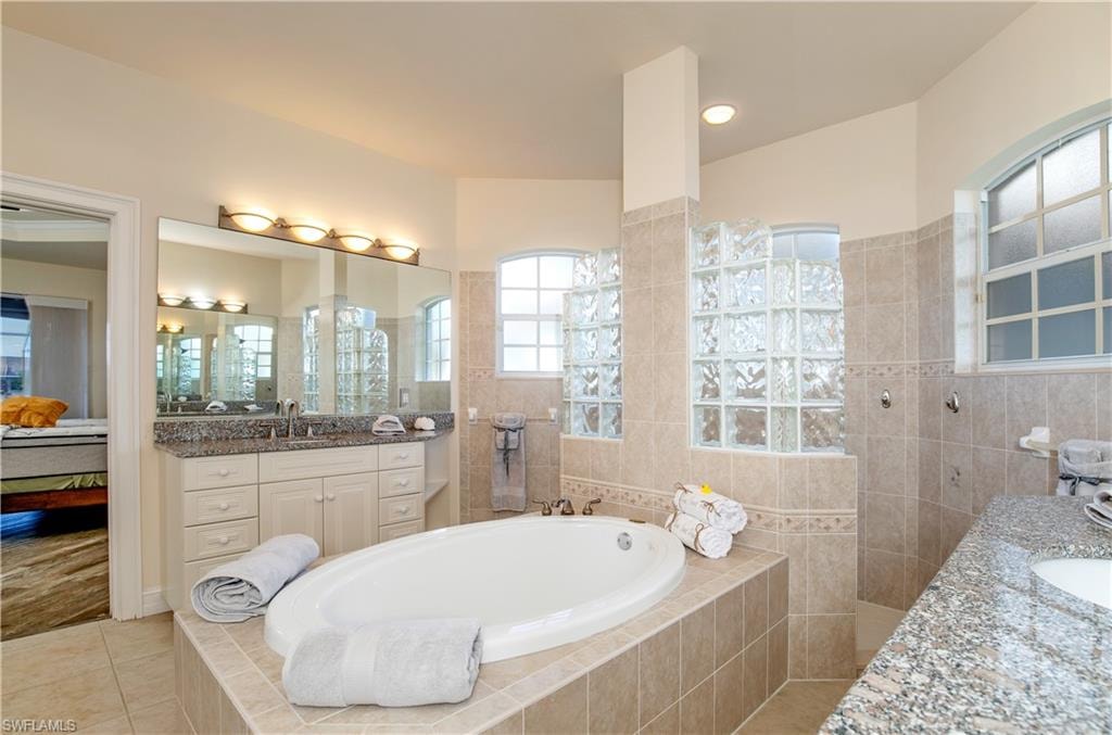 View of HUGE Primary-1 Spa/Bath with Walk Around Hollywood Block Sun Lit Shower, Roman Tub plus Separate Granite Mirrored Vanities [Doorway to Primary-1 Bedroom Suite]