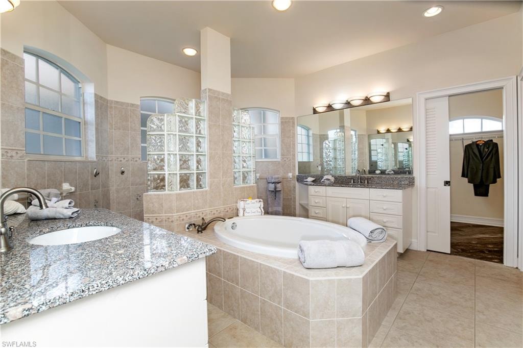 View of huge HUGE Granite Primary-1 Bath with Separate Mirrored Vanities, Walk Around Hollywood Block Sun Lit Shower, Roman Tub and HUGE Walk In Closet.
