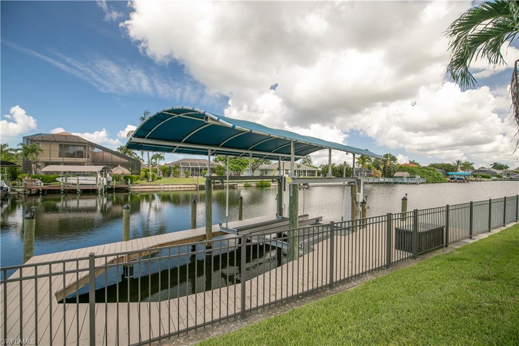 View of Captains Walk 10,000 LB Boat Lift with Canopy and Fenced Back Yard on Gulf Access Canal