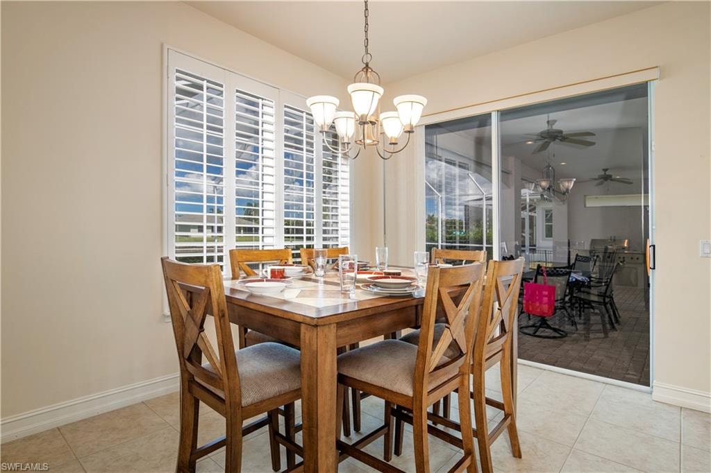 View of  Chandelier'd Family Dining with Plantation Shutter and Slider to Huge Lanai Under Truss and Pool/Spa Deck