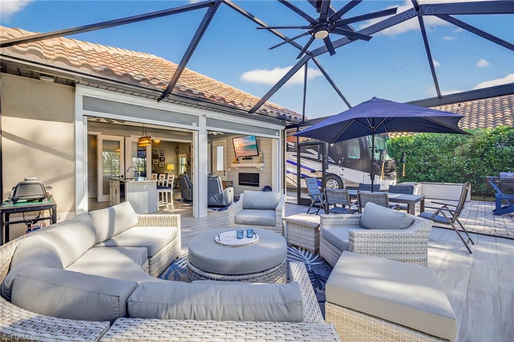 View of patio with a sunroom, glass enclosure, outdoor dining area, an outdoor living space, and a ceiling fan