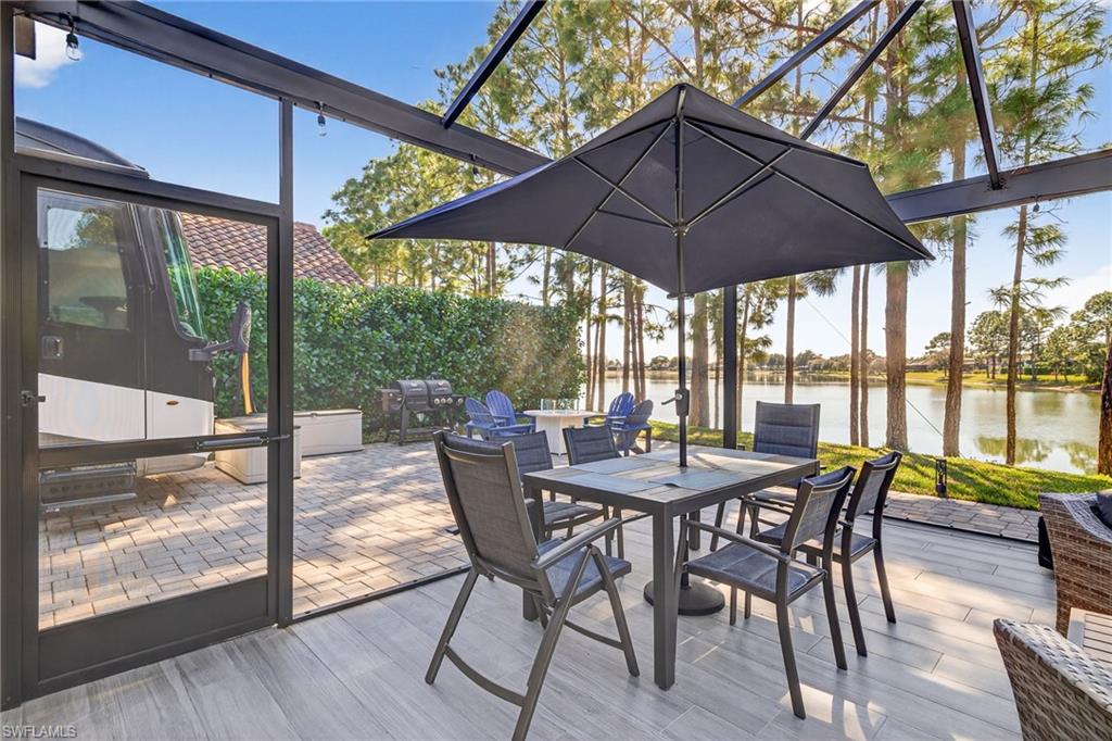 Sunroom with a water view, a patio, and outdoor dining area