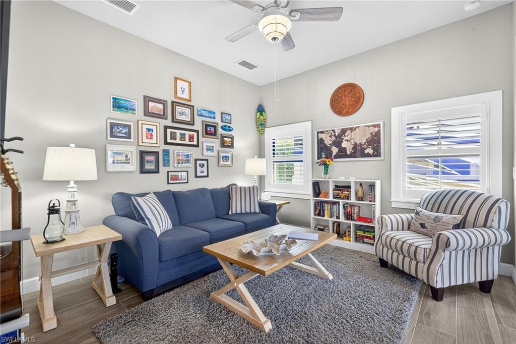 Living area with ceiling fan and wood finished floors