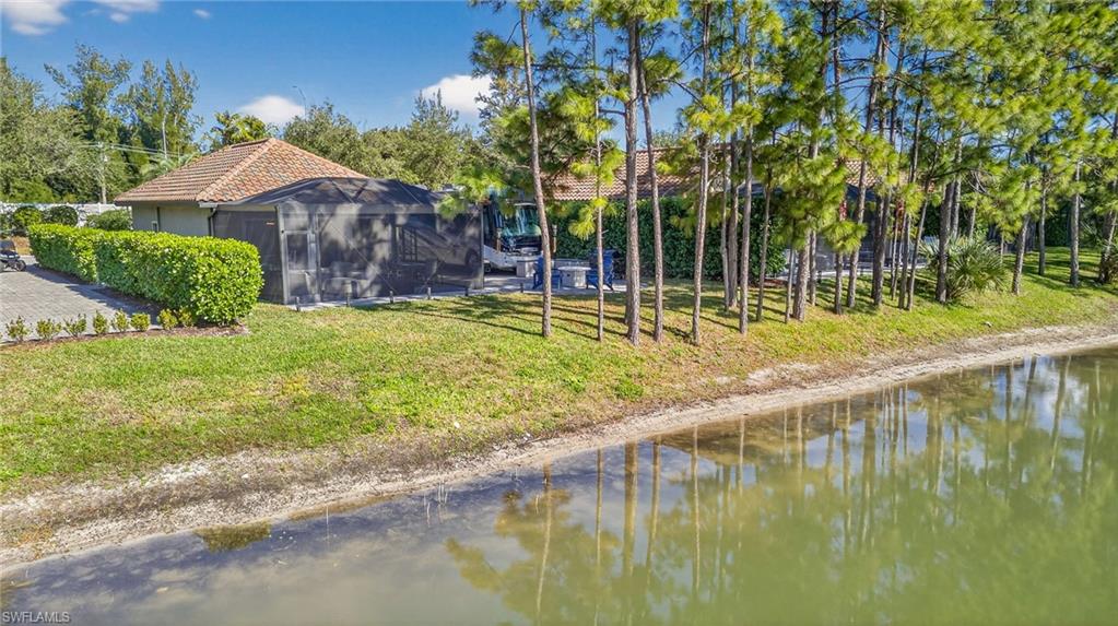 Rear view of house featuring a lawn and a water view