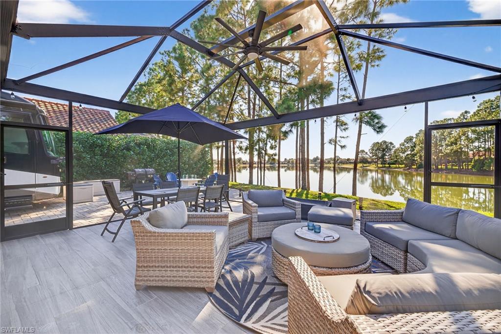 View of patio / terrace featuring a sunroom, a water view, an outdoor living space, and outdoor dining space