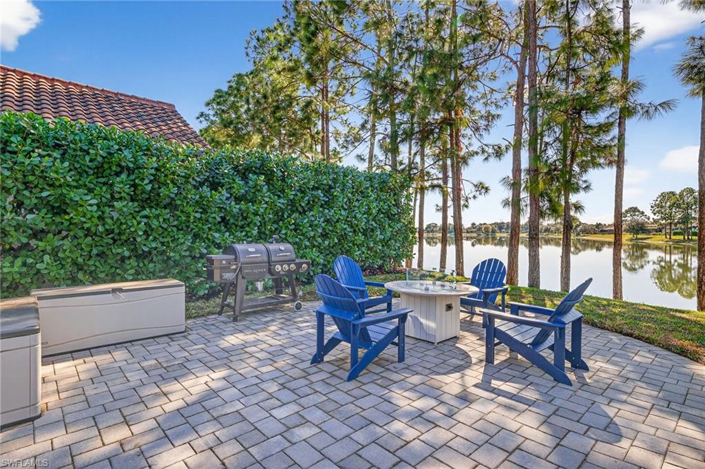 View of patio with an outdoor fire pit, a water view, and area for grilling