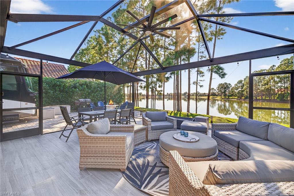 View of patio featuring a sunroom, outdoor dining area, a water view, and outdoor lounge area