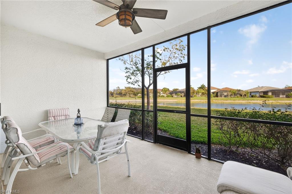Sunroom / solarium with outdoor dining area, a ceiling fan, and a water view