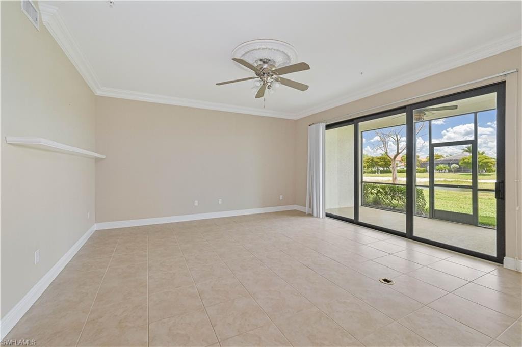 Spacious room featuring neutral wall tones, large format tile flooring, crown molding, and a ceiling fan with a decorative medallion