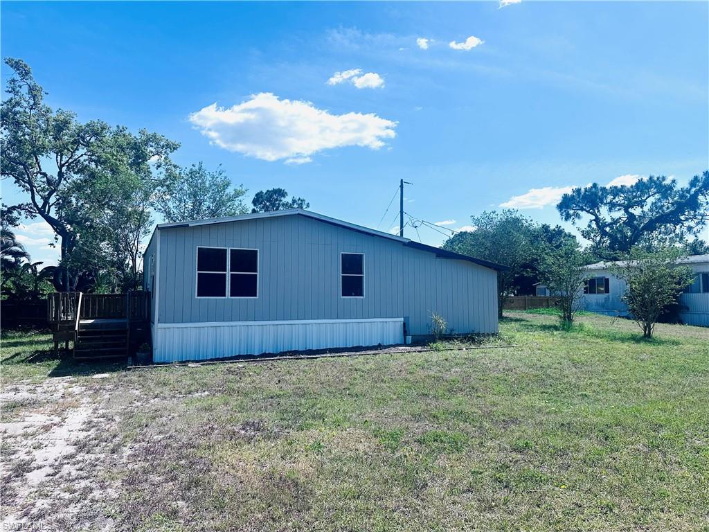 View of property exterior featuring a yard and a deck