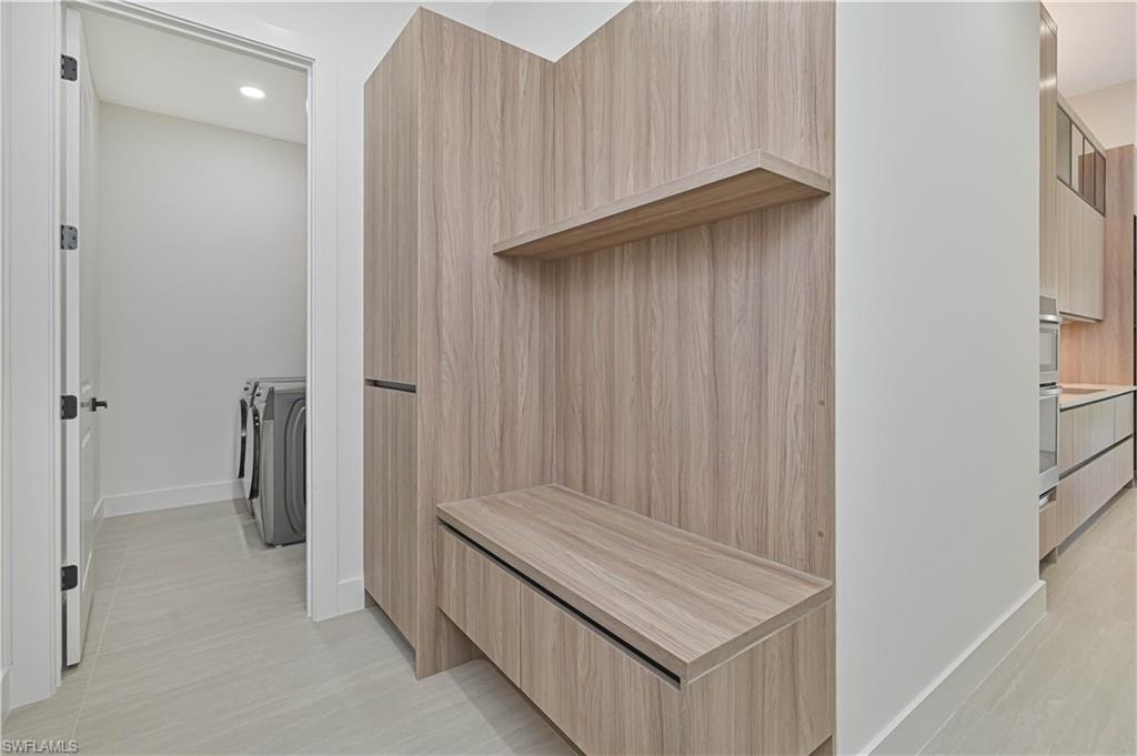 Mudroom with recessed lighting and independent washer and dryer