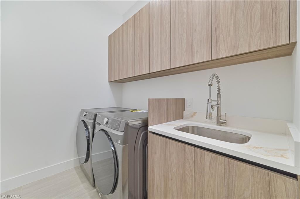 Laundry room featuring separate washer and dryer and cabinet space