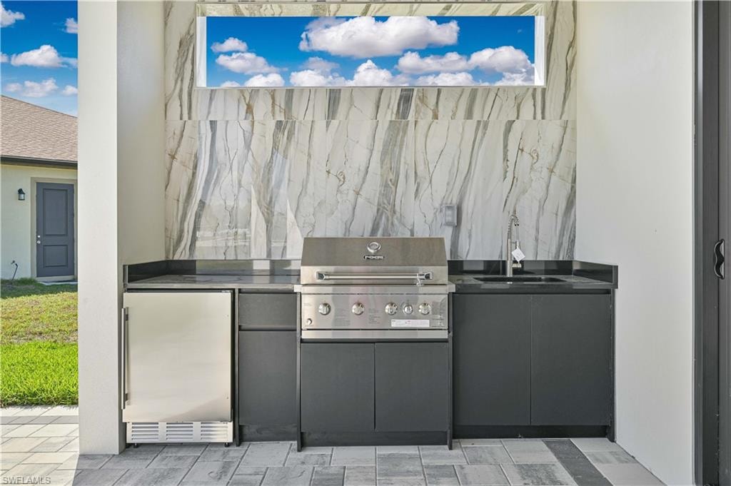 View of patio featuring exterior kitchen and a sink