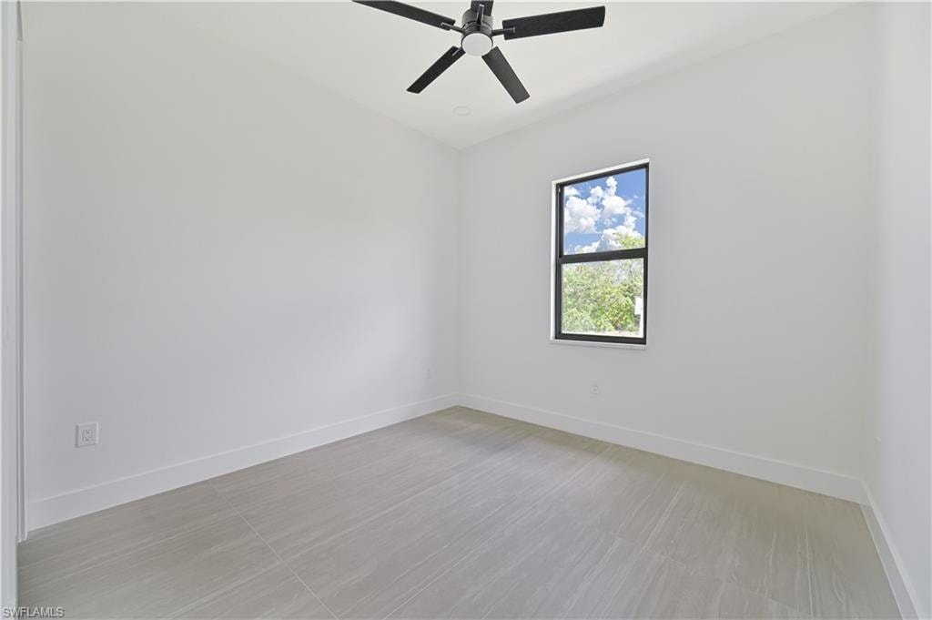 Unfurnished room featuring baseboards and ceiling fan