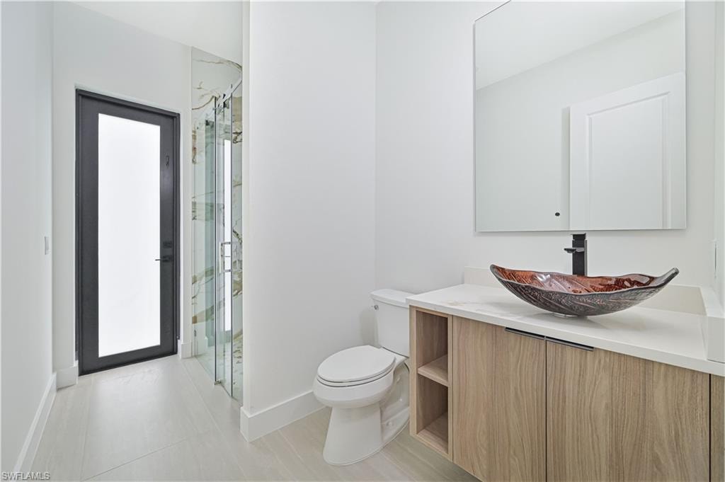 Full bath with vanity and a marble finish shower