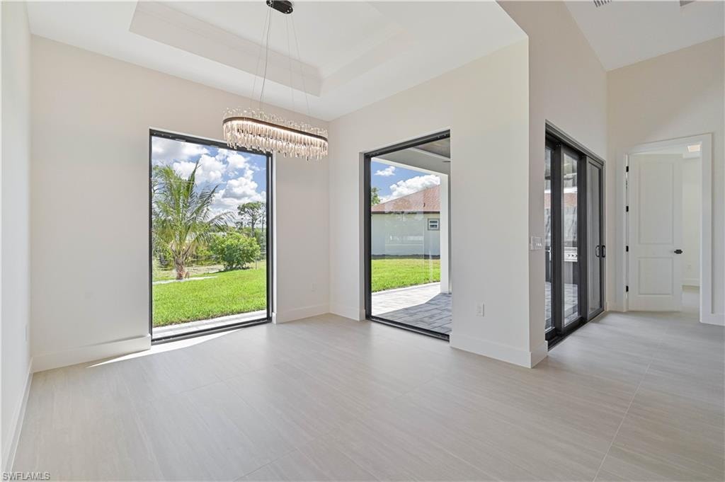 Unfurnished dining area featuring a tray ceiling and hanging lights