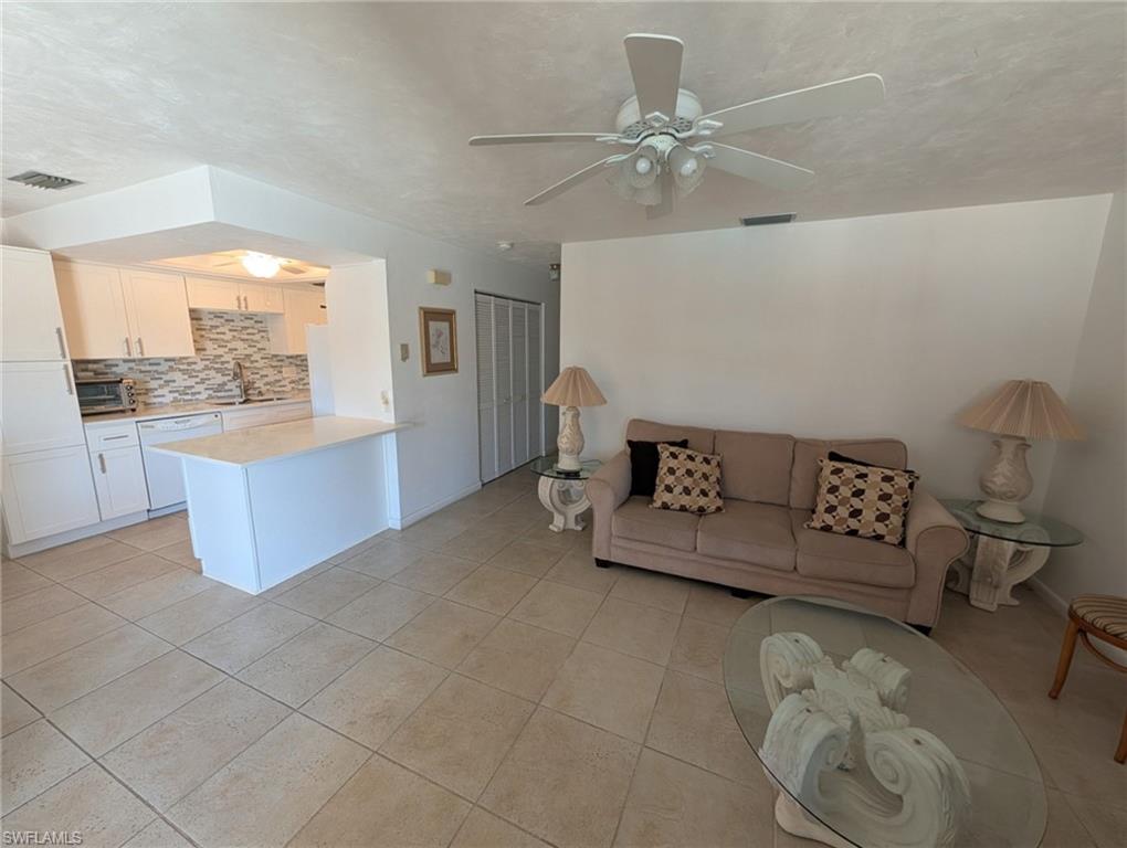 Living room with ceiling fan and light tile patterned floors