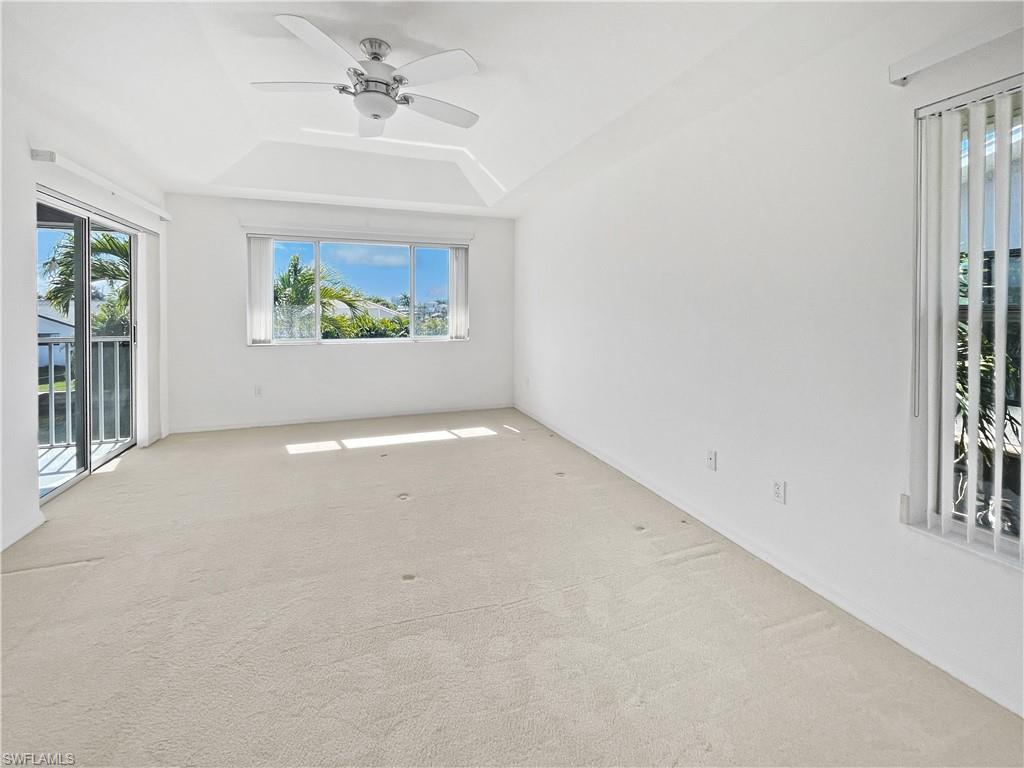 Carpeted Master bedroom with healthy amount of natural light, a raised ceiling, and ceiling fan