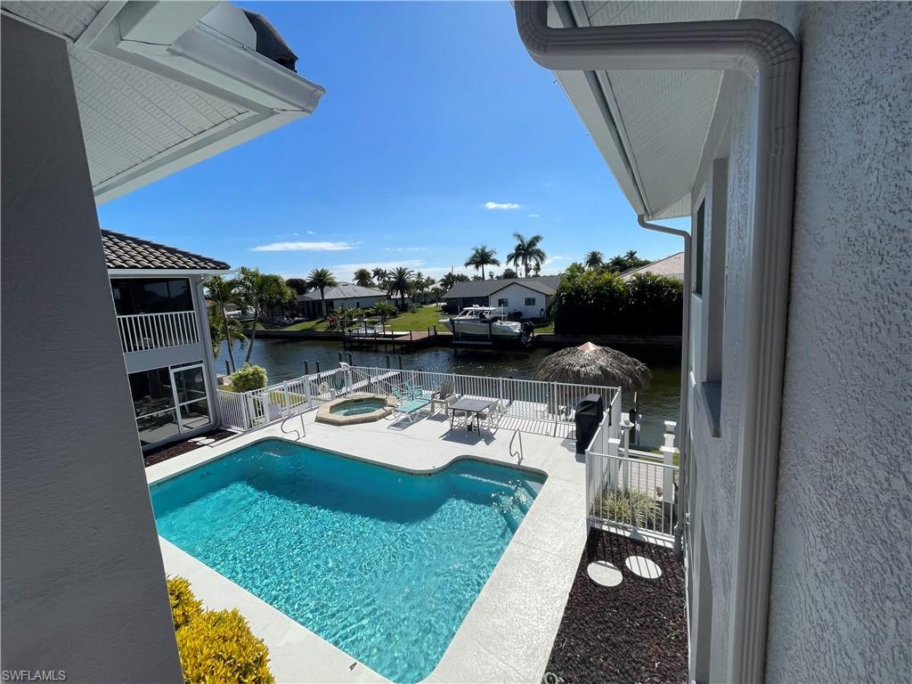 View of pool with an in-ground hot tub, patio surround, and a water view