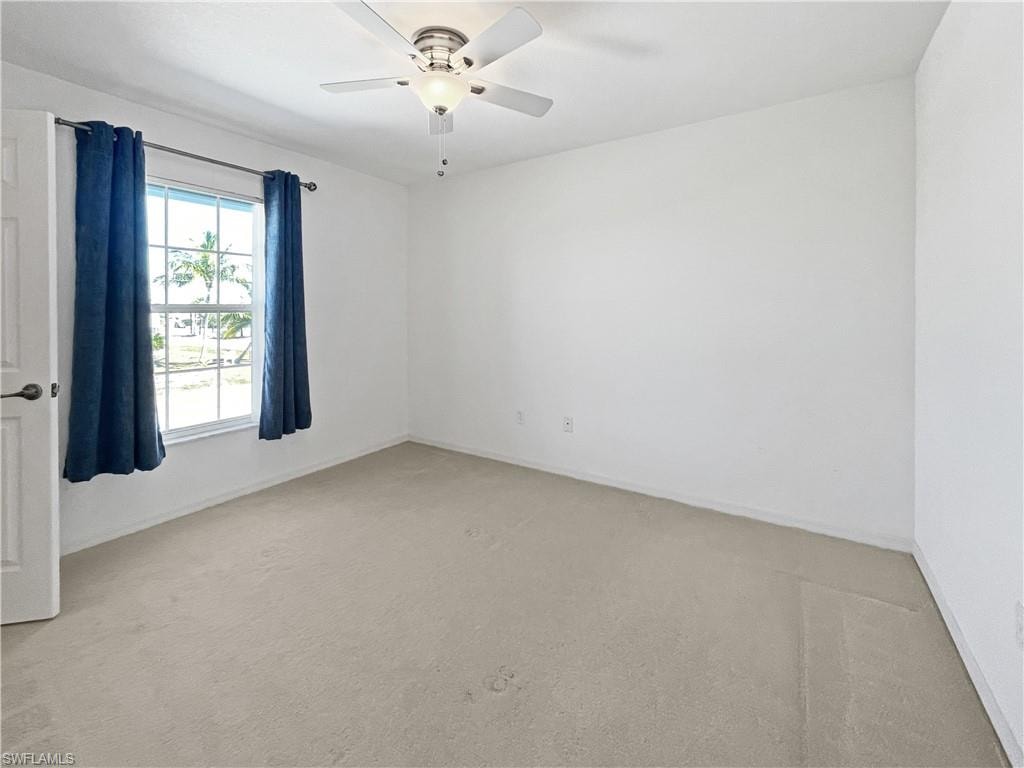 Guest bedroom with light carpet and a ceiling fan