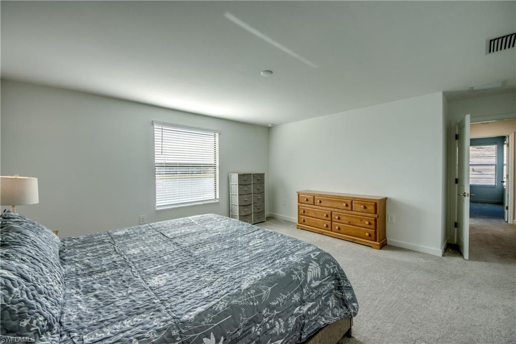 Bedroom with light carpet and baseboards