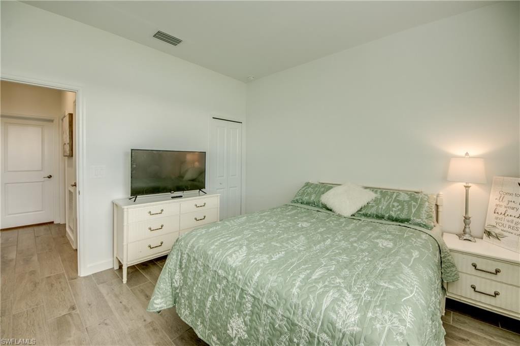 Bedroom featuring wood finish floors and a closet