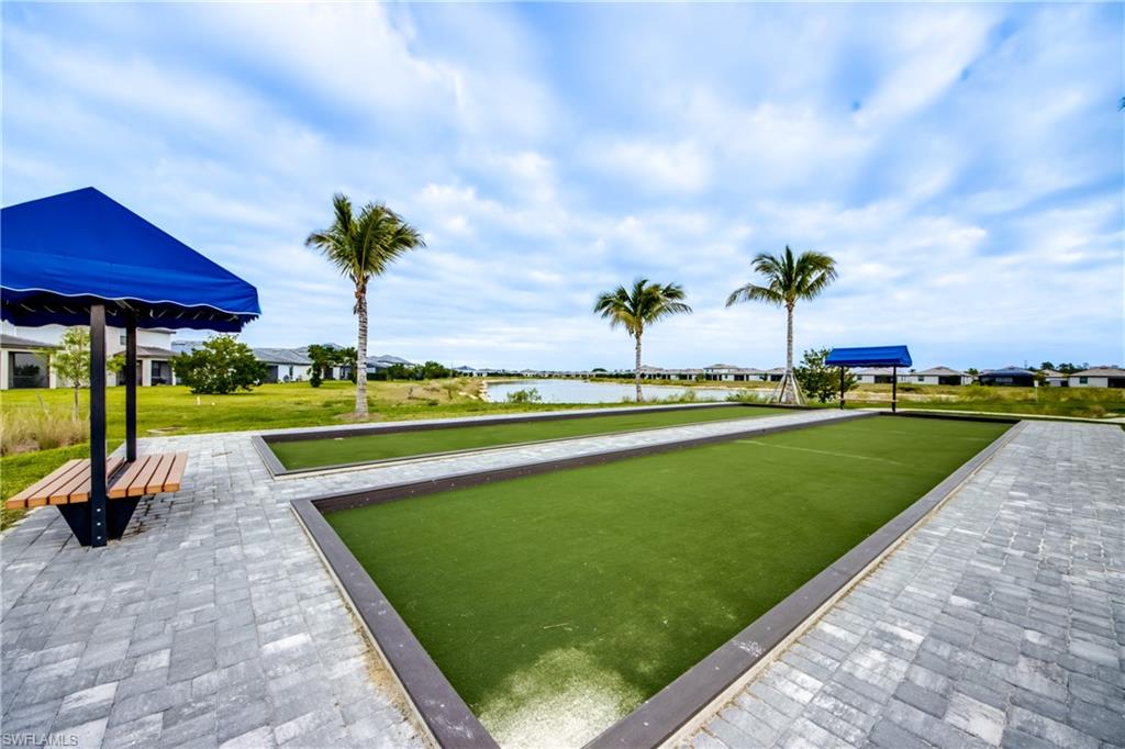 View of property's community featuring a water view, a game area, a residential view, and a lawn