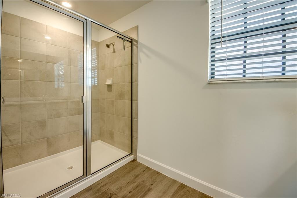 Bathroom featuring a shower stall and wood finished floors