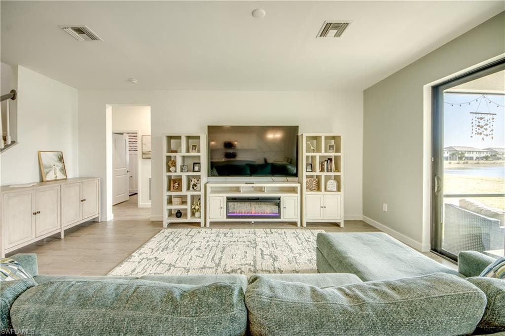 Living area featuring wood finished floors and a glass covered fireplace