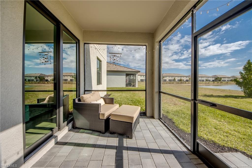 Sunroom / solarium featuring a residential view and a water view
