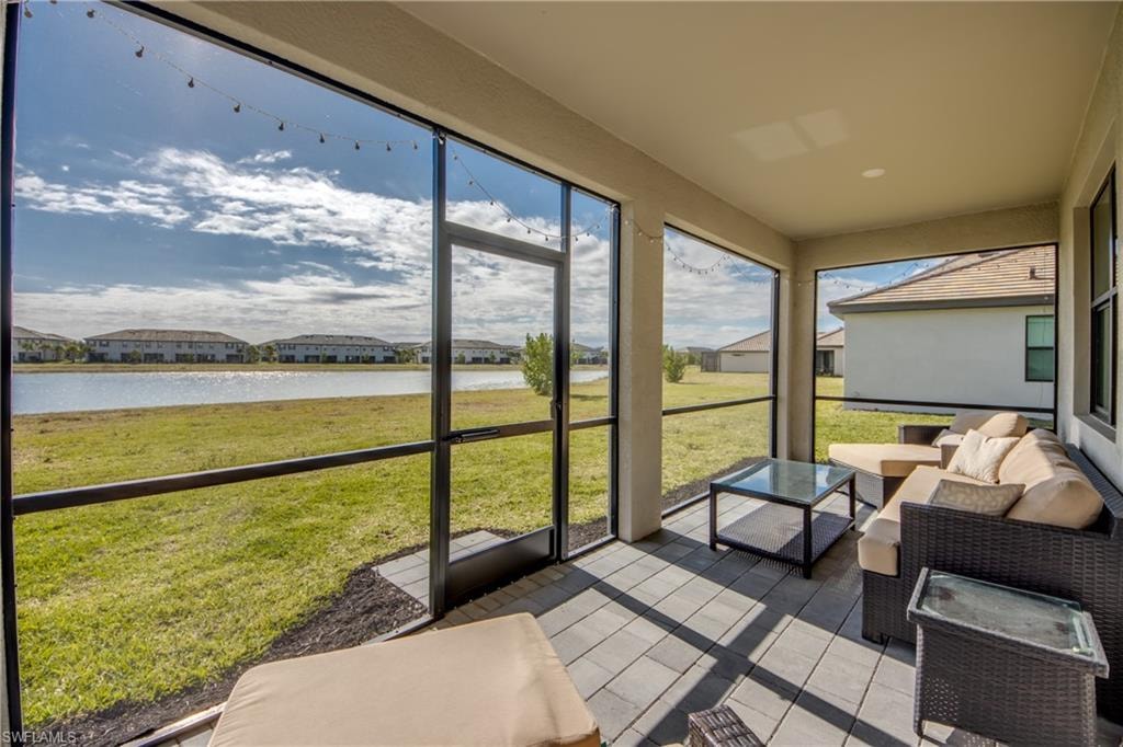 Sunroom / solarium featuring a residential view, outdoor lounge area, and a water view