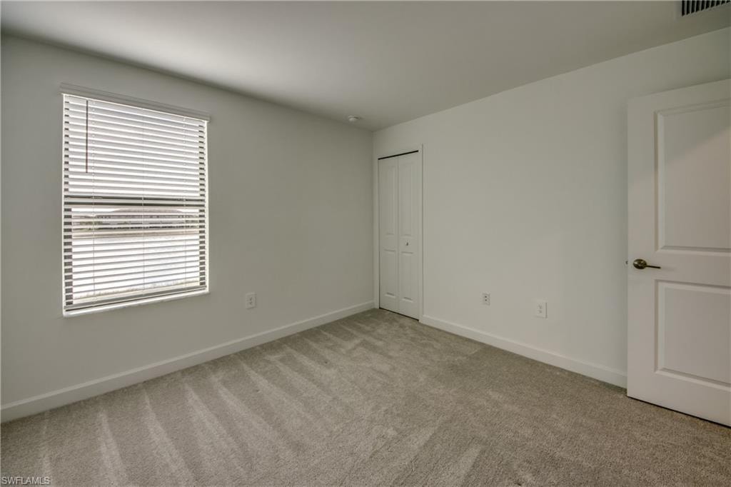 Unfurnished bedroom featuring light colored carpet and a closet