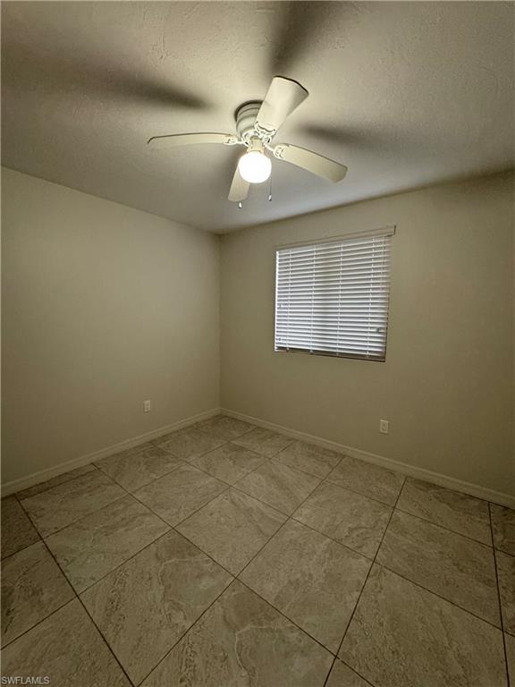 Empty room with a textured ceiling and ceiling fan
