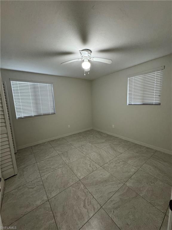 Empty room with baseboards and ceiling fan