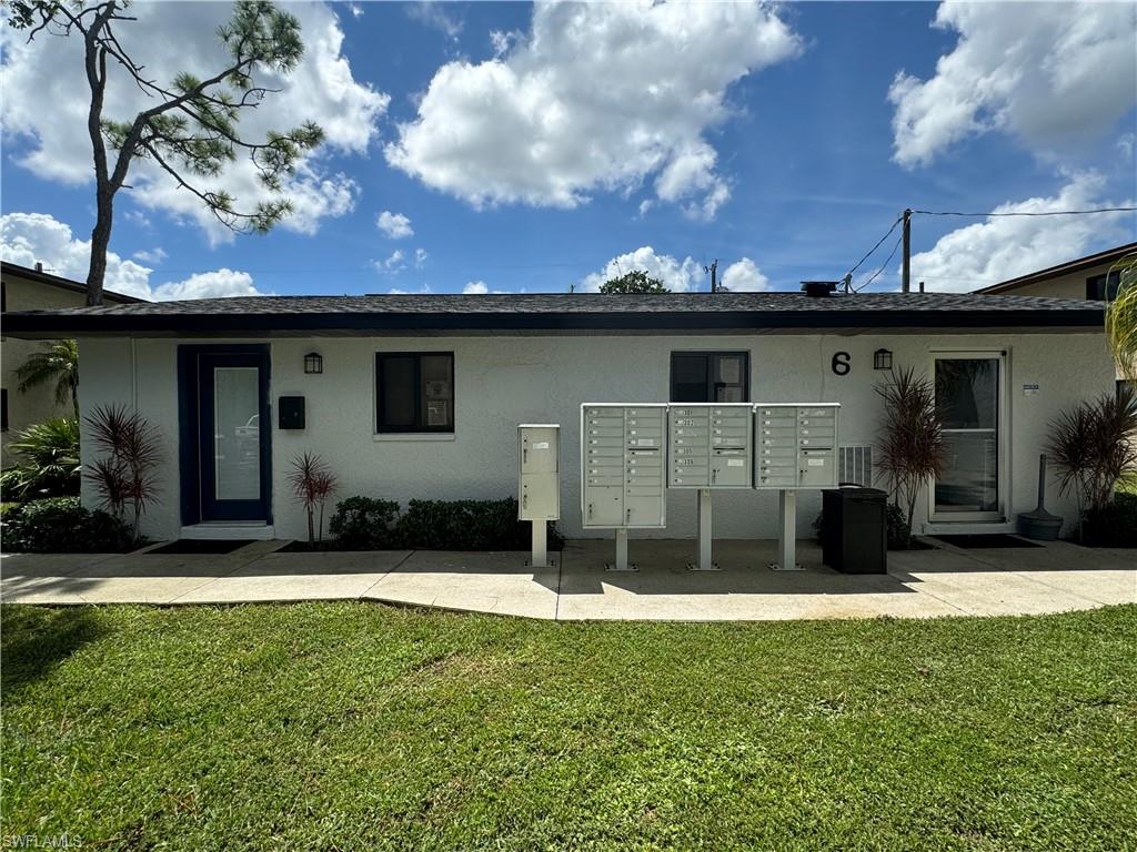 Back of property featuring stucco siding and a lawn