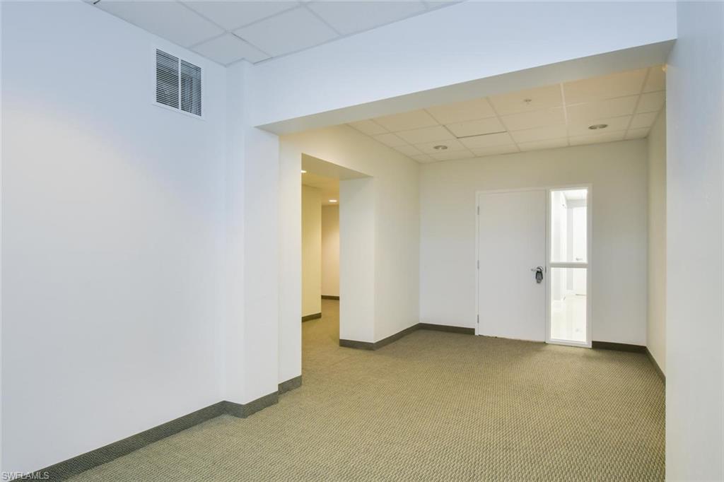 Unfurnished room with a paneled ceiling and carpet flooring