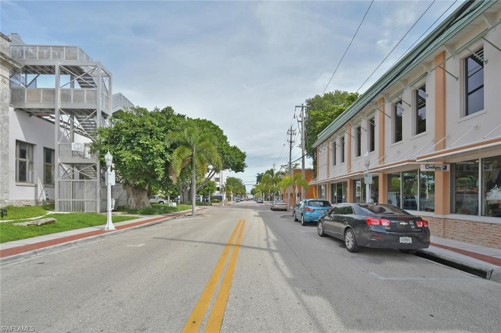 View of asphalt road featuring sidewalks and curbs