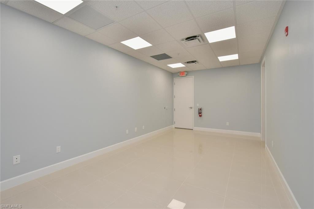 Spare room featuring light tile patterned floors and a paneled ceiling