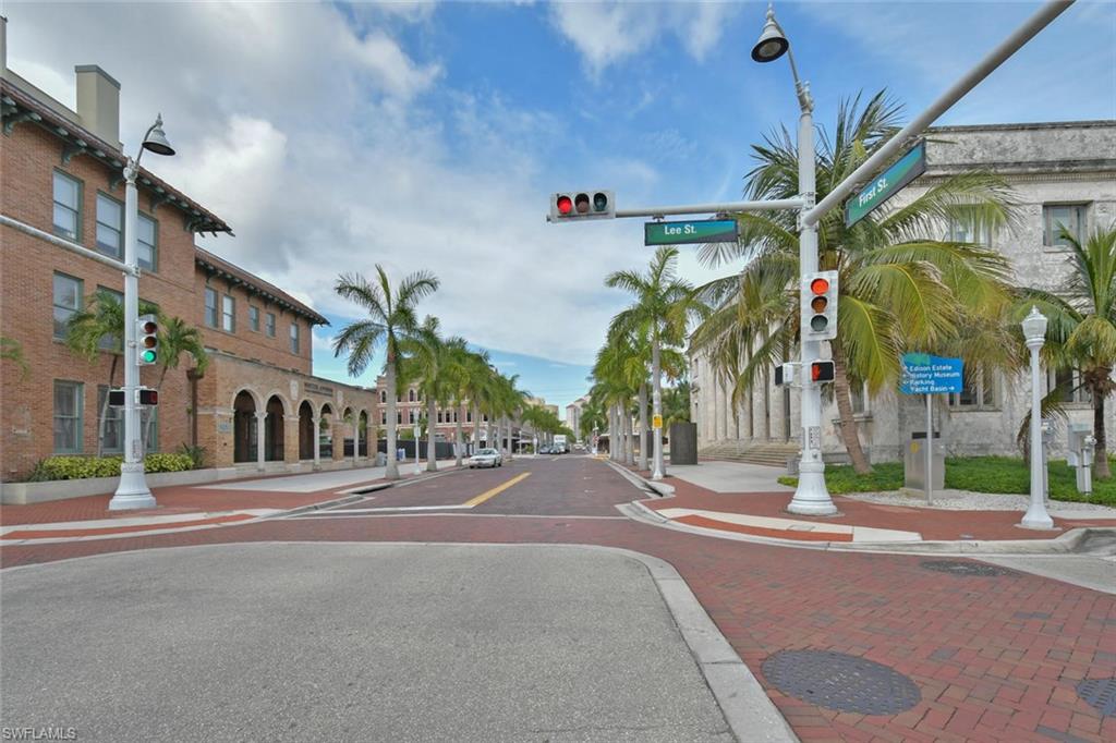 View of asphalt street with sidewalks, traffic lights, and curbs