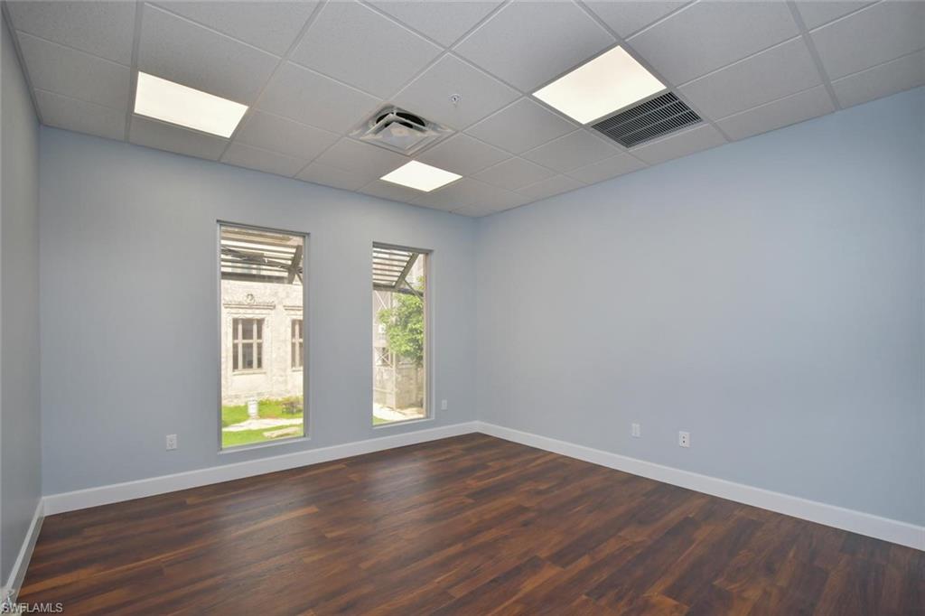 Spare room with a paneled ceiling and dark wood-style floors