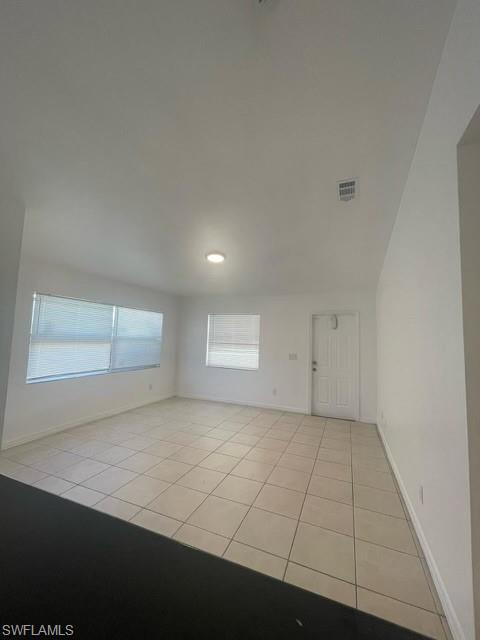 Unfurnished room with light tile patterned floors and baseboards