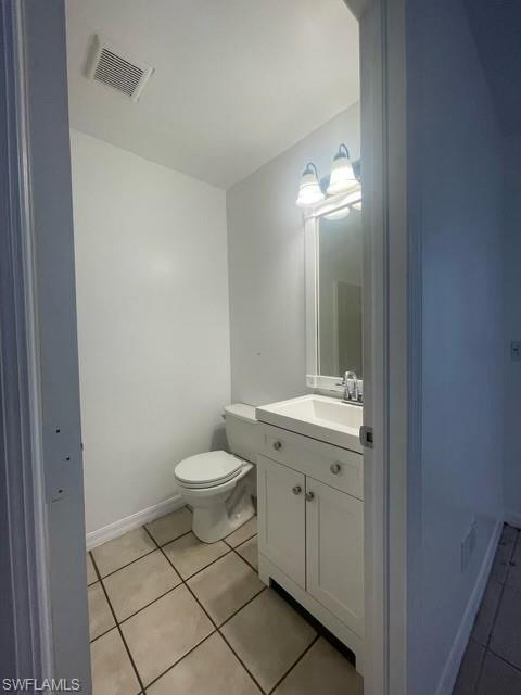 Half bathroom with vanity and light tile patterned floors