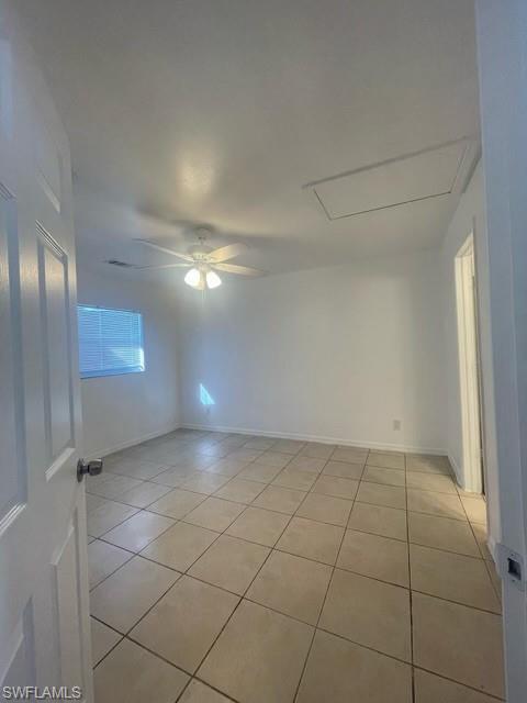 Empty room with ceiling fan and light tile patterned floors