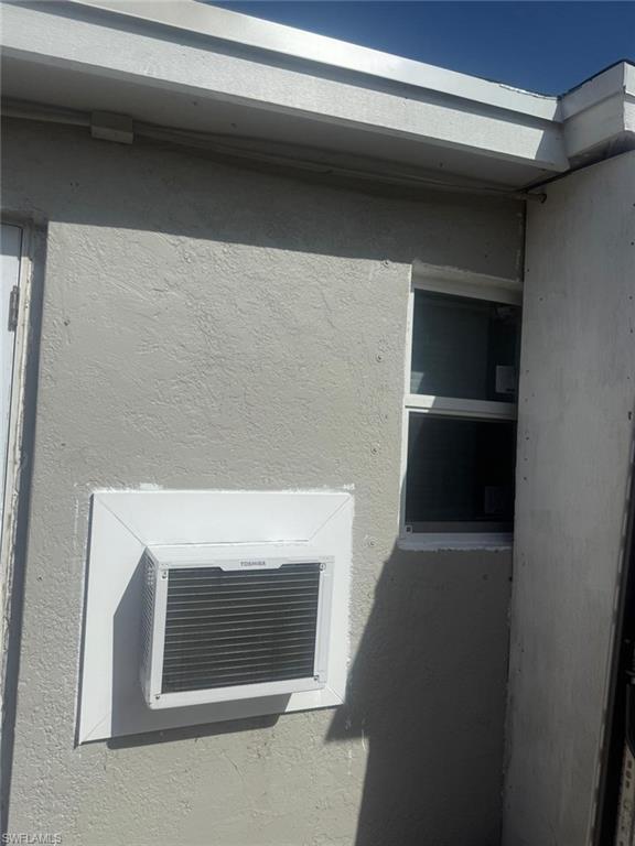 Exterior view of a wall mounted air conditioner and stucco siding