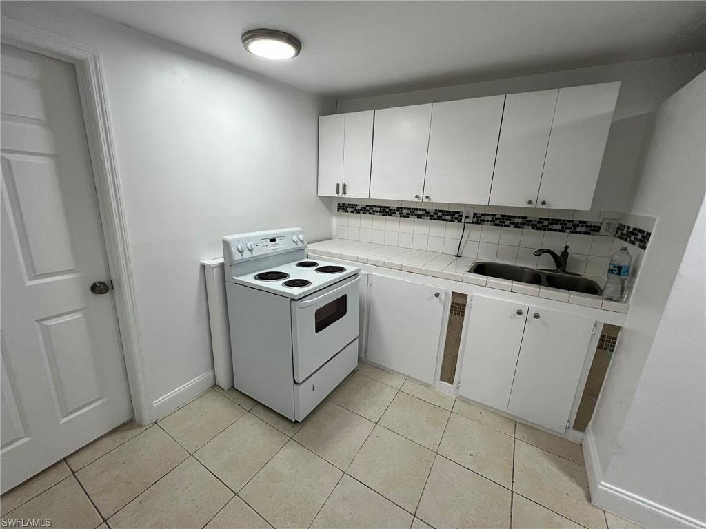 Kitchen featuring white cabinetry, tile countertops, white electric range, and tasteful backsplash