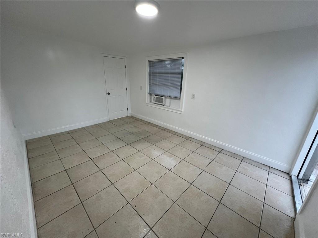 Unfurnished room with light tile patterned floors and baseboards